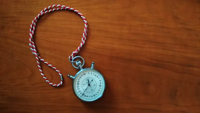Close-up shot of an antique stopwatch with rope on wooden table. How to write landing page software service standards as events, clocks and evidence